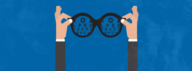 hands holding glasses with an eye chart seen in the lenses